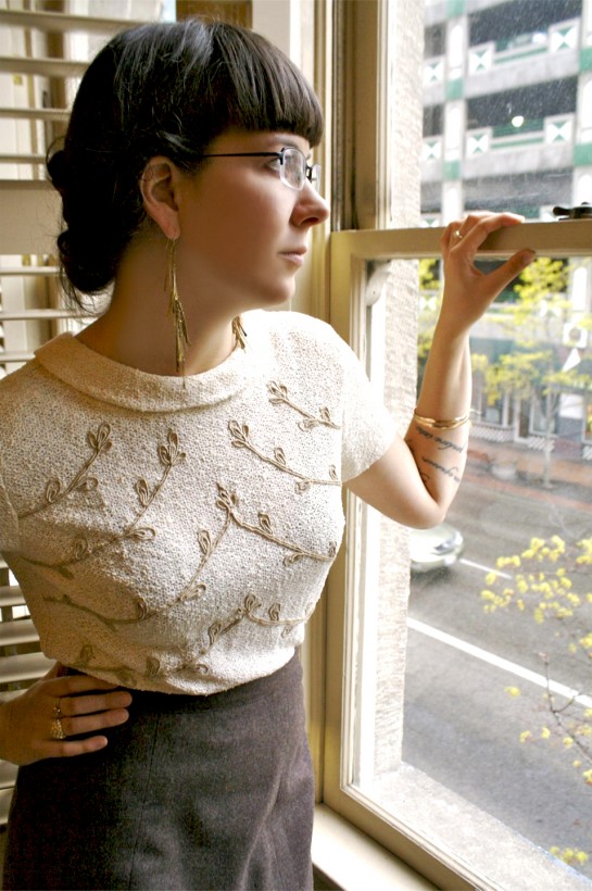 photographer Kelly Lynae, Hazel Cox earrings, knit clothing, standing at the window, gold bangles, antique jewelry, thrifting for fashion
