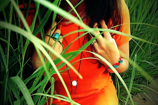handmade beadwork, hiding in the grass, bright orange fashion statement, white coral necklace, grasping